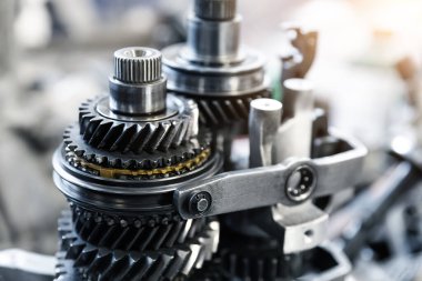 Otomatik vites parçalarını garajdaki tezgaha ya da tamirat ya da tamirat için fabrika istasyonuna kapatın. Araç parçası detayı. Karmaşık endüstriyel mekanizma arka planı