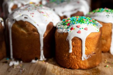 Birçok geleneksel Doğu Avrupa Rus ve Ukrayna 'nın Paskalya pastası kulich' i ahşap masa sabah güneş ışığına şekerli kremayla süslenmiş. Lezzetli el yapımı Hıristiyan Ortodoks bayram ekmeği.