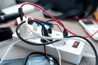 Evde aşırı yüklenmiş priz prizi var. Karışık ev aletleri ve şarj aletleri karışıklığı