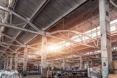 Eski terk edilmiş çürümüş sanayi fabrikası ya da beton ve çelik inşaat iskeleti kirişleri ile iç yapı tesisi. Güneş ışığı çatı penceresinden içeri giriyor. Kirli endüstriyel altyapı