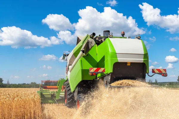 Szenische Rückansicht Großer leistungsstarker Industriemähdrescher erntet an strahlenden Sommer- oder Herbsttagen goldene reife Getreidefelder. Landwirtschaftliche gelbe Feldmaschinen Landschaft Hintergrund — Stockfoto