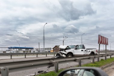 Karayolu yolundaki hurda araba kazası. Kazadan sonra polis ve çekiciyi beklerken büyük beyaz bir araç hasar gördü.