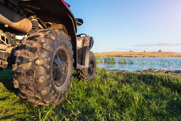 ATV awd quadbike motocykl pov pohled v blízkosti jezera nebo řeky rybník pobřeží s krásnou přírodou krajiny nebe pozadí. Offroad dobrodružství výlet expedice. Extrémní sportovní rekreační aktivity — Stock fotografie