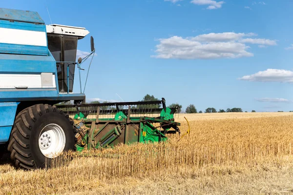 Szenische Frontansicht Großer leistungsstarker Industriemähdrescher erntet an strahlenden Sommer- oder Herbsttagen goldene reife Getreidefelder. Landwirtschaftliche gelbe Feldmaschinen Landschaft Hintergrund — Stockfoto