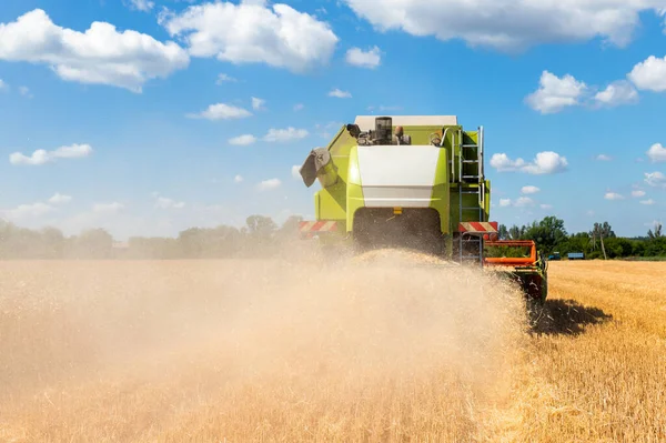 風景フロントビュー明るい夏や秋の日に黄金の熟した小麦のシリアルフィールドを読み取る収穫機を組み合わせた大きな赤の強力な産業。農業用イエローフィールド機械景観の背景 — ストック写真