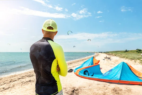 Νεαρός ενήλικας καυκάσιος ταιριάζει αρσενικό πρόσωπο απολαμβάνουν ιππασία kite surf σκάφους στον ήλιο uv προστασία κοστούμι σε φωτεινή ηλιόλουστη μέρα κατά του μπλε ουρανού στη θάλασσα ή ακτή του ωκεανού. Θαλάσσια σπορ αδρεναλίνη διασκέδαση περιπέτεια οξύτητα — Φωτογραφία Αρχείου