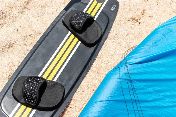 Sopra la vista surf board e attrezzature aquilone sulla spiaggia di sabbia spot sport acquatici in luminosa giornata di sole contro la costa dell'oceano mare con molti kiter equitazione surf camp scuola. Concetto di sport di viaggio attivo — Foto Stock