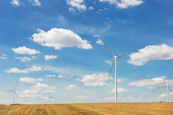 Vista panorâmica da paisagem da nova estação de geração de energia eólica moderna branca contra céu e campo azuis claros. Emissões zero sustentáveis limpas eletricidade alternativa indústria de parques eólicos — Fotografia de Stock