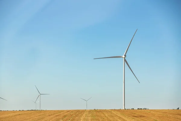 Vista panorâmica da paisagem da nova estação de geração de energia eólica moderna branca contra céu e campo azuis claros. Emissões zero sustentáveis limpas eletricidade alternativa indústria de parques eólicos — Fotografia de Stock