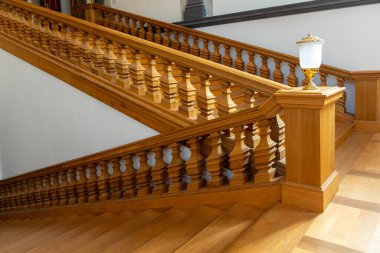 Sıcak ahşap balyalar, gün ışığında merdiven boyunca zarif bir şekilde tekrarlanır. Pürüzsüz yüzeyler ve ustalıkla hazırlanmış detaylar yumuşak gölgelerle rafine edilmiş atmosfer yaratır..