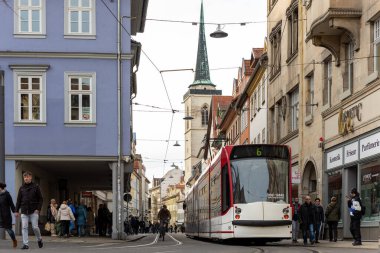 Erfurt, Almanya - 10 Şubat 2024. Tarihi Fischmarkt Caddesi 'ndeki tramvay hareket halindeki Erfurt şehir merkezi yayaları eski mimariyi satıyor. Kentsel yaşam tarzı sahnesi Avrupa 'nın günlük hayat yolculuğu kültür şehri.