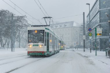 Magdeburg, Almanya - 9 Ocak 2026: Winter City tramvayı ağır kar yağışı, buzlu hava koşullarında hareket eden toplu taşımacılığı gösteriyor. Kar, güvenlik riskini sezonluk hava koşullarını engelledi.