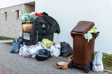 Büyük plastik çöp konteynırları, şehir merkezindeki ya da banliyödeki Alman yerleşim yerindeki çöp torbalarıyla dolu. Geri dönüşümsüz çöp öğütücü. Çöp servisi grevi.