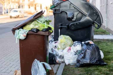Büyük plastik çöp konteynırları, şehir merkezindeki ya da banliyödeki Alman yerleşim yerindeki çöp torbalarıyla dolu. Geri dönüşümsüz çöp öğütücü. Çöp servisi grevi.