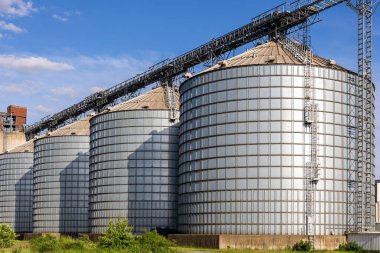 Mavi gökyüzüne karşı tahıl ambarı tahıl ambarı ambarı manzarası. Tarımsal tarım arazisi kırsal sanayi silo manzarası. Değirmen deposu çiftlik tesisi.