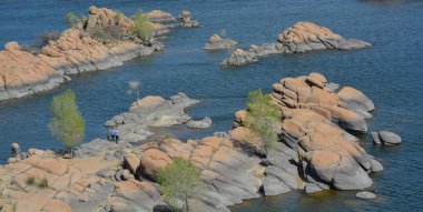 Watson Gölü 'nde parlak mavi suyla korunmasız granit kaya yatağı var. Prescott, Yavapai County, Arizona 'da. 