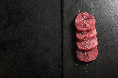 Mutfak kesim tahtasındaki çiğ et madalyonları..