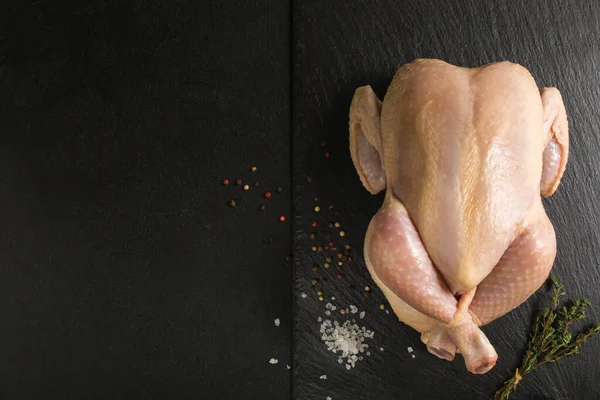 Pollo crudo preparado para asar en una tabla de cortar de cocina de piedra. — Foto de Stock