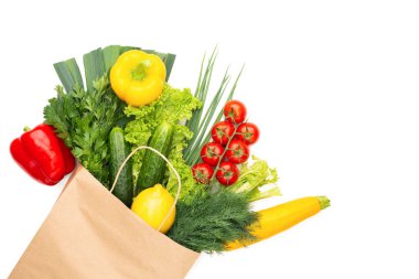 Beyaz arka planda izole edilmiş bir kese kağıdındaki sebze ve bitkiler. Konsept: Süpermarkette veya markette alışveriş ve Sağlıklı Vejetaryen Gıda.