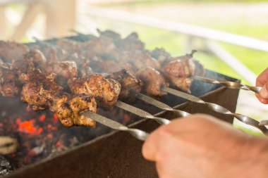 The cook prepares a shish kebab on the grill. BBQ party . Close-up.
