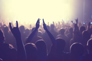 Büyük bir konser kulübünde konserin izleyicileri..