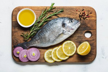 Limon ve baharatlarla hazırlanmış kesme tahtasındaki taze dorado. Üst görünüm.