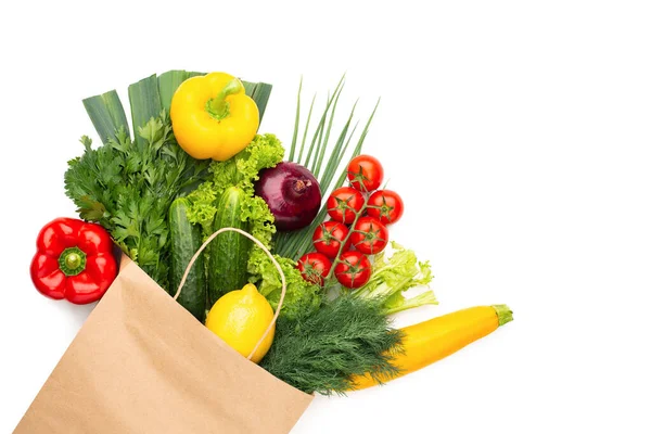 Beyaz arka planda izole edilmiş bir kese kağıdındaki sebze ve bitkiler. Konsept: Süpermarkette veya markette alışveriş ve Sağlıklı Vejetaryen Gıda.