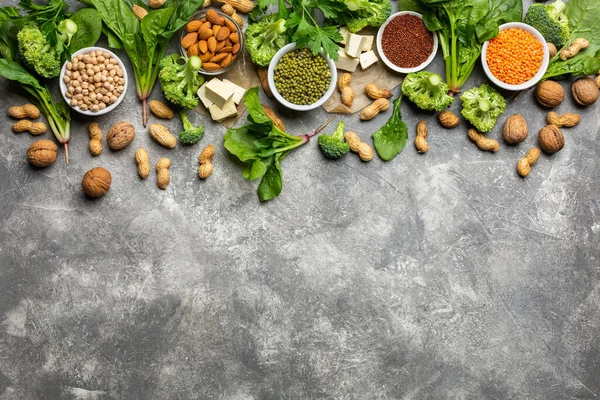 Vejetaryenler için protein: soya peyniri, sebze, fındık, tohum ve baklagiller beton bir arka planda. Kavram: Sağlıklı temiz yiyecekler.