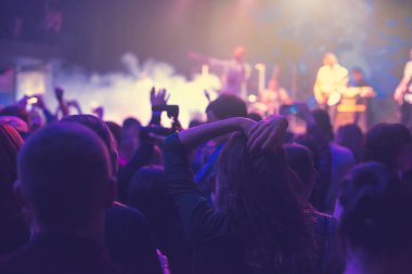 Küçük bir konser kulübündeki konserde seyirci kalabalığı. Alkışlayın ve sahnenin yanında dans edin. Seyirci ışıkla dolu..