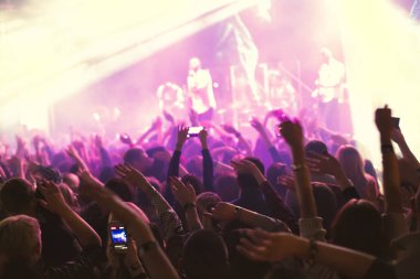 Küçük bir konser kulübündeki konserde seyirci kalabalığı. Alkışlayın ve sahnenin yanında dans edin. Seyirci ışıkla dolu..