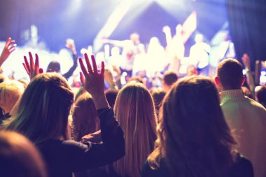 Küçük bir konser kulübündeki konserde seyirci kalabalığı. Alkışlayın ve sahnenin yanında dans edin. Seyirci ışıkla dolu..