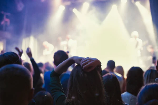 Küçük bir konser kulübündeki konserde seyirci kalabalığı. Alkışlayın ve sahnenin yanında dans edin. Seyirci ışıkla dolu..