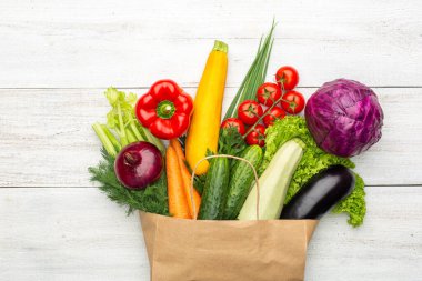 Beyaz ahşap bir arka planda kağıt bir torba içindeki ürünler. Süpermarketten ya da marketten alışveriş yapmak