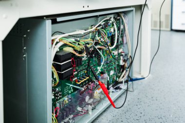 Tıbbi tanı ekipmanları içinde görünür devre kartları, kablolama ve elektronik bileşenleri olan açık x-ışını makinesinin yakın plan görüntüsü.