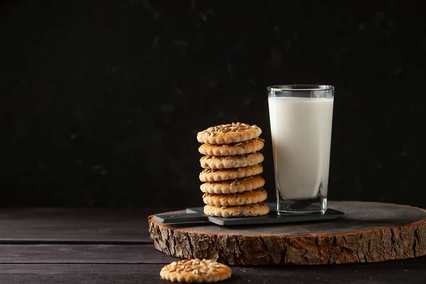新鲜健康的牛奶和自制饼干放在深色木桌上 — 图库照片