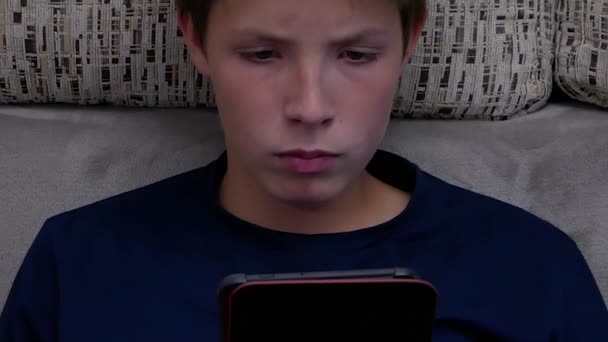 Πορτρέτο ενός αγοριού που διαβάζει ένα e-book. — Αρχείο Βίντεο