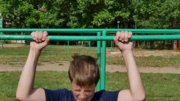 A cute boy pulls himself up on a horizontal bar. — Stock Footage A cute boy pulls himself up on a horizontal bar. Royalty Free Stock Footage