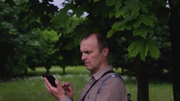 電子ナビゲーションの助けを借りて道路を探している森の中の観光客. — ストック動画