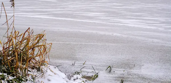 La riva innevata di un fiume ghiacciato. — Foto Stock