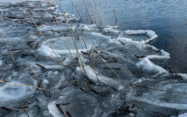 Orilla del lago sin derretir cubierta de hielo viejo. — Foto de Stock