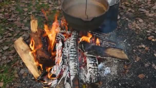 Cooking in a metal pot over a fire. — Stock Video