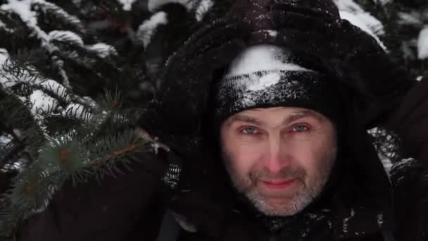 Porträt eines Mannes mit schwarzem Hut, der mit Schnee bedeckt ist — Stockvideo