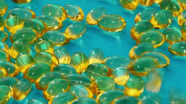 Риб'ячий жир капсули капають на синю поверхню . — стокове відео