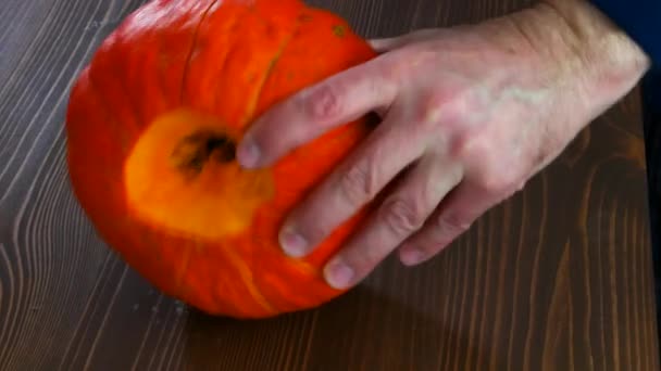 Mužské ruce rozřízly dýni na půl nožem.. — Stock video