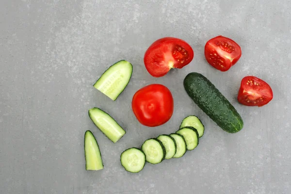 Image of fresh cucumbers and tomatoes on a light gray background. — стоковое фото