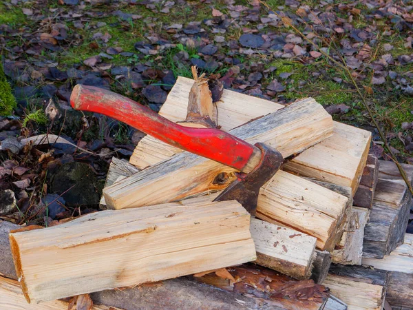 An old red shabby axe on a pile of firewood. — Foto de Stock