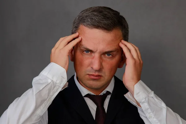 Portrait of a man holding his head because of a headache. — Zdjęcie stockowe