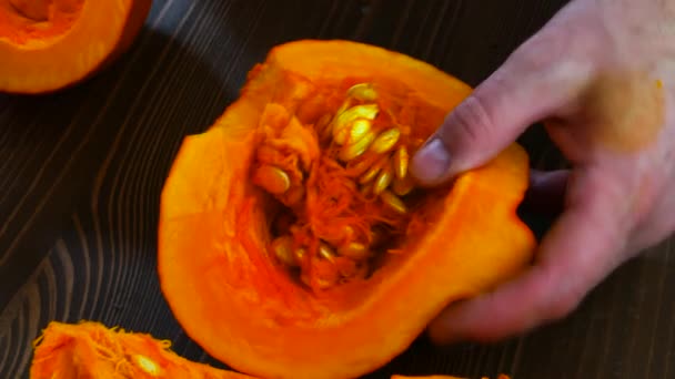 Male hands carve the core of a pumpkin with a knife. — Stok video
