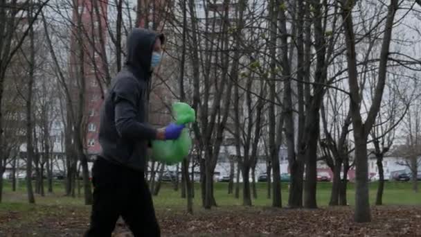 Un voluntario camina por la calle con un paquete de basura y residuos recogidos. — Vídeo de stock