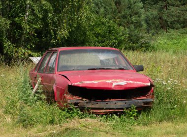 Ormandaki eski hasarlı kırmızı araba..